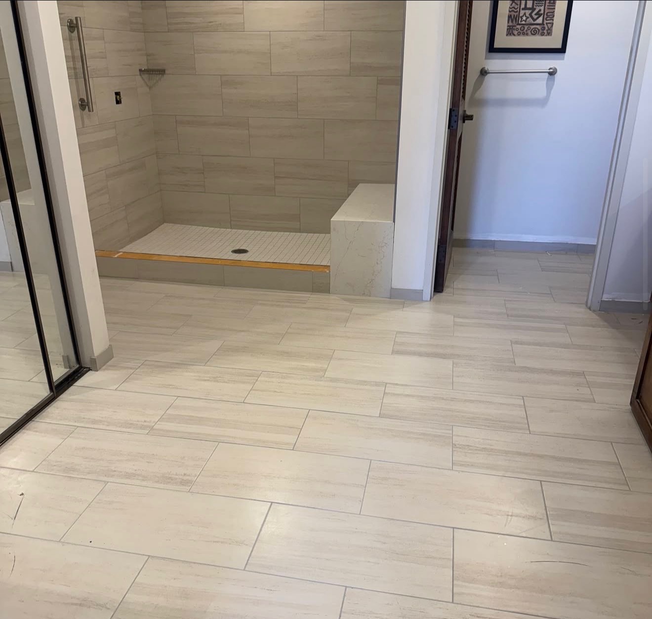 Completed walk-in shower with bench and glass door
