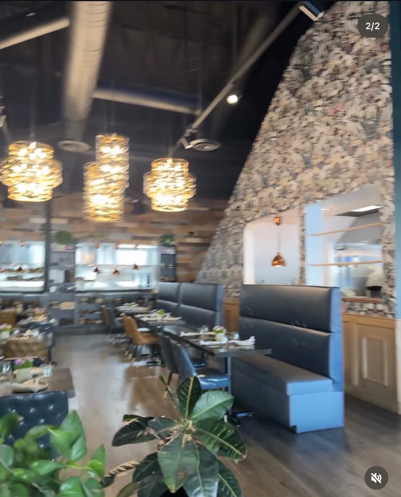 Restaurant dining area with stone wall and pendant lighting